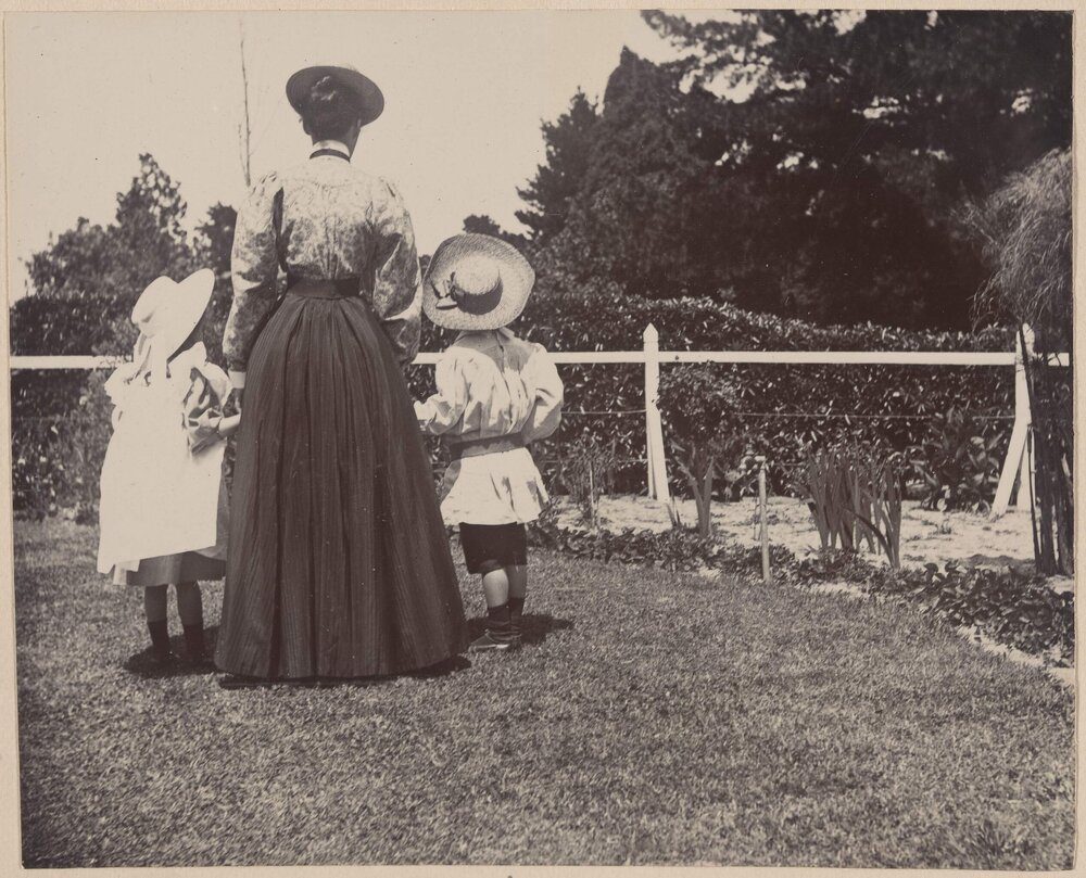 [Woman holding hands with young girl and boy] 