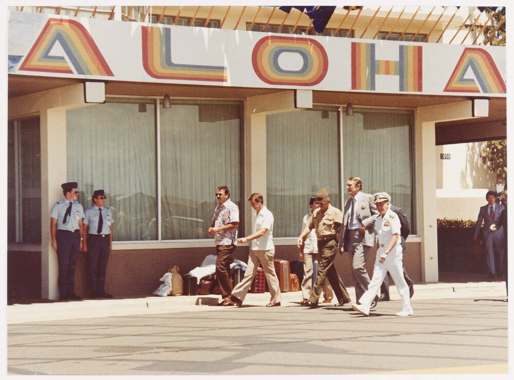 [Malcolm Fraser and others under a sign reading Aloha]