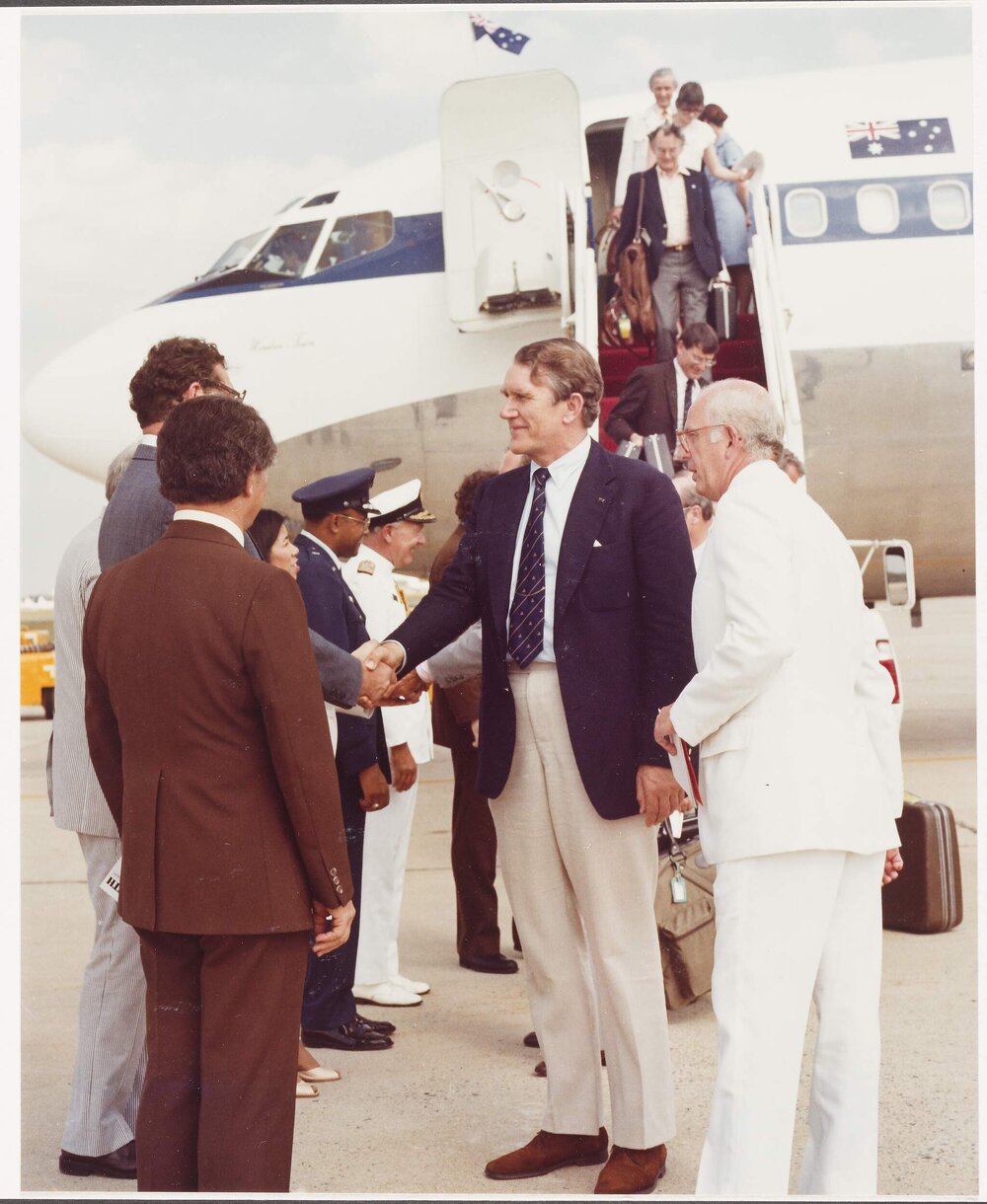 [Malcolm Fraser and others next to an aeroplane]
