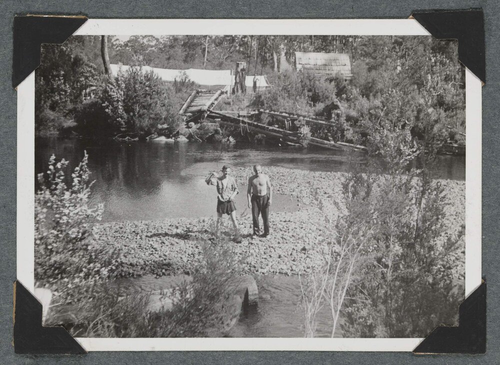 [Two men standing in front of river]