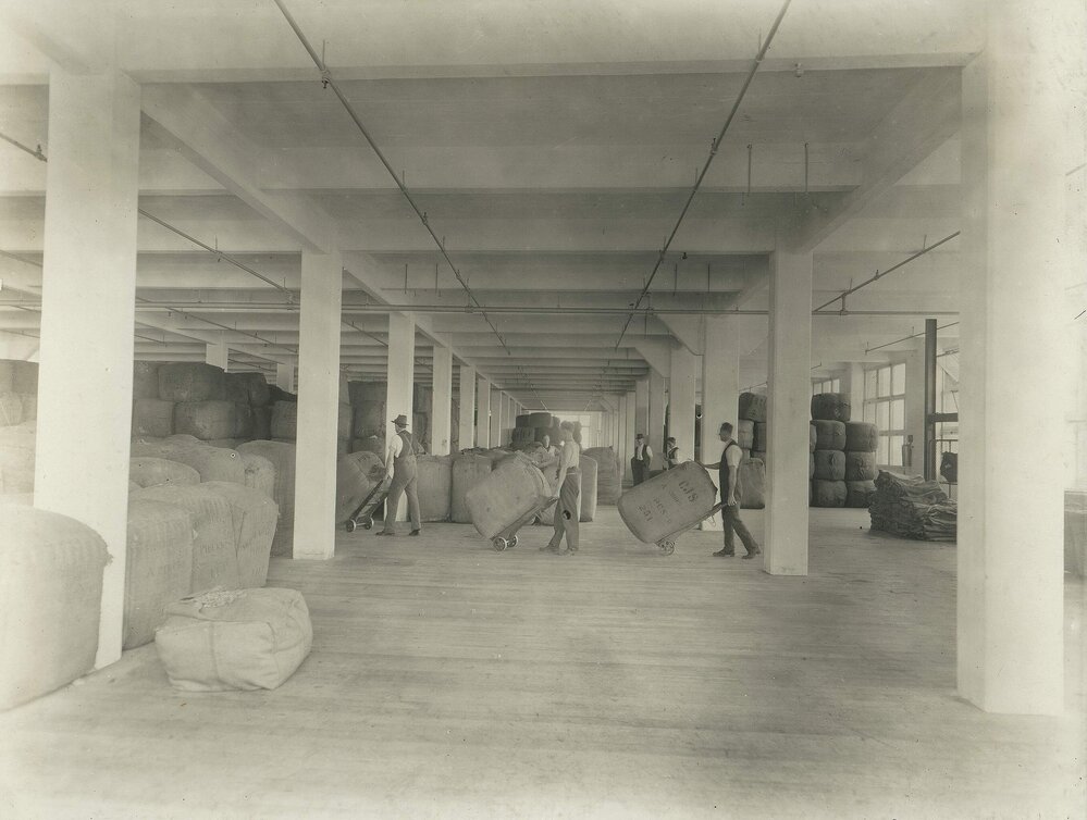Men using handtrucks to move bales of wool at Foy and Gibson Pty. Ltd. Gibsonia Woollen Mills in Collingwood, Victoria.