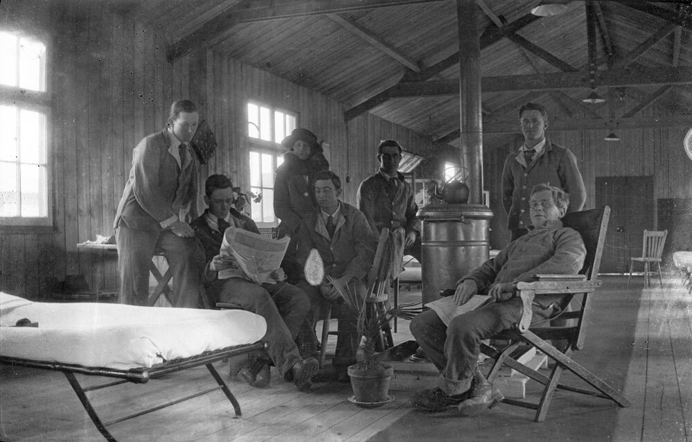 Group of men and a woman gathered around a heater