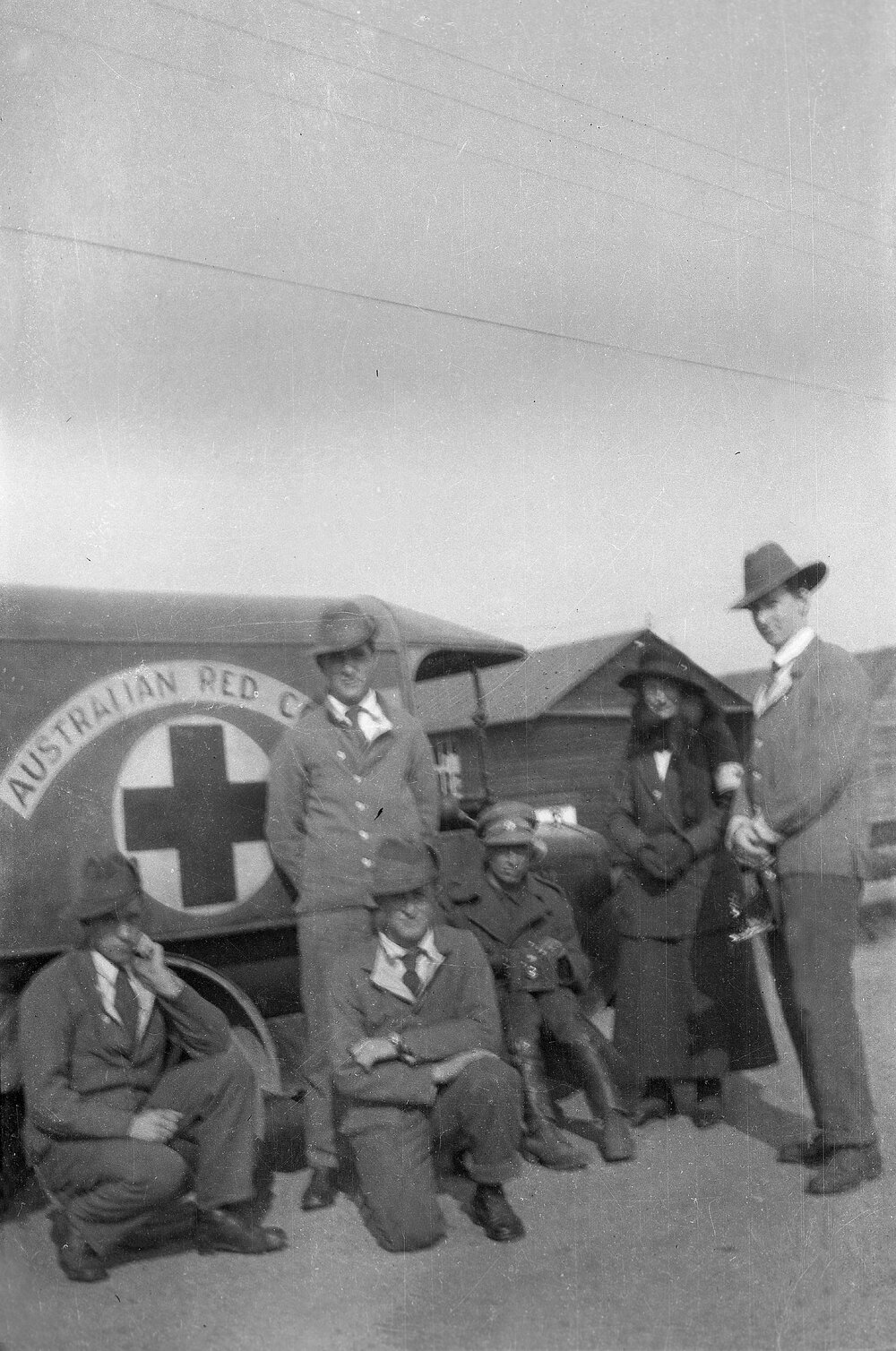 Five men and a woman in front of an Australian Red Cross vehicle
