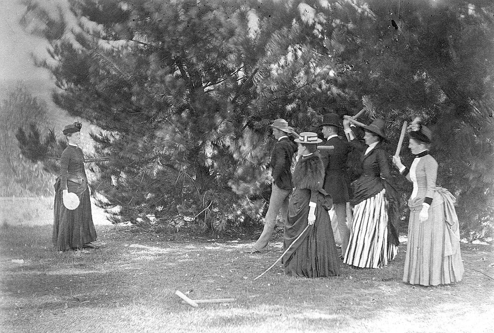 Group of men and women in garden, with games equipment
