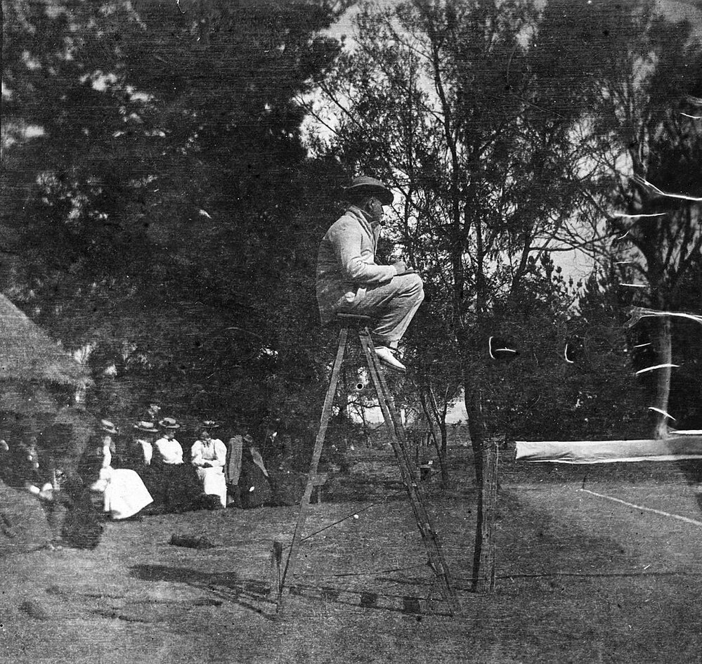 Photo of group of women seated next to tennis court