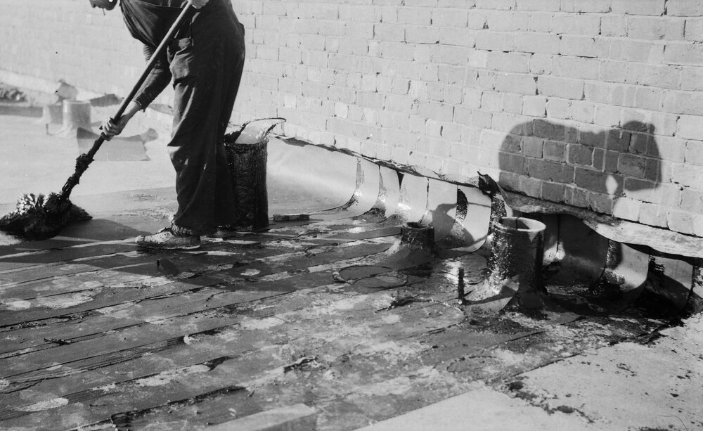 University building under construction.  Roof - laying overlapping malthoid.
