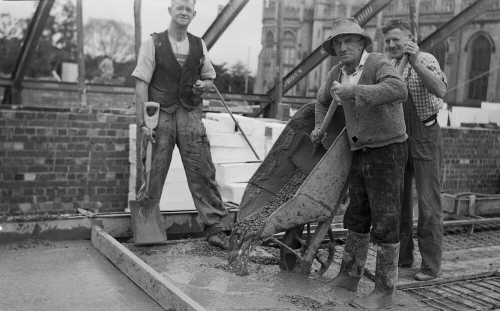 University building under construction.  Bill &amp; 2 labourers pouring concrete.