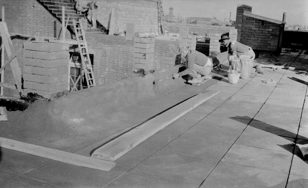 University building under construction.  Covering parapet on West side of Cuming Theatre.