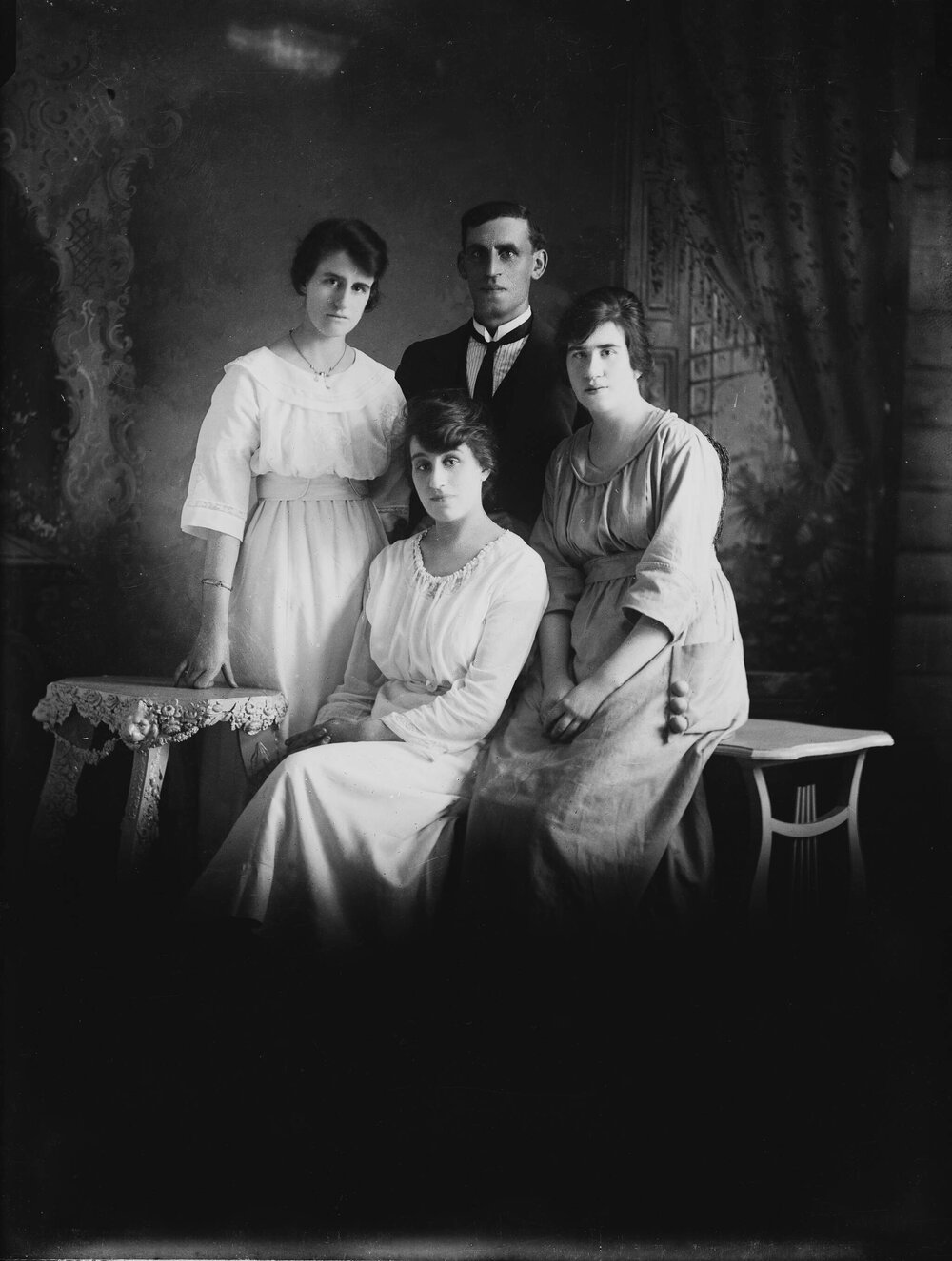 Studio group portrait of three women and a man.  Family name Russell.