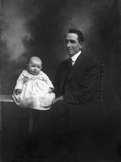 Studio portrait of Mr. C. Peterson and a baby.