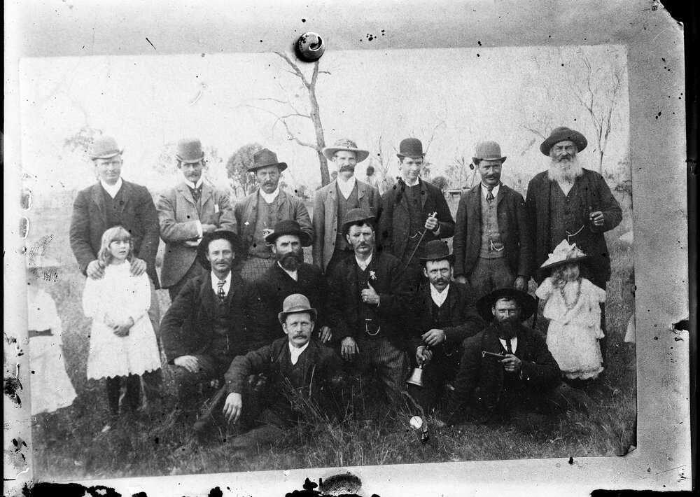 A posed group of unidentified people in an outdoor setting.
