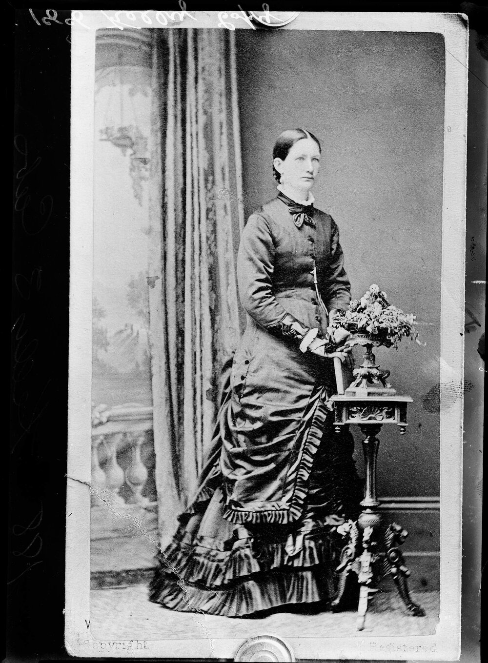 Studio portrait of a woman wearing a large spotted scarf.