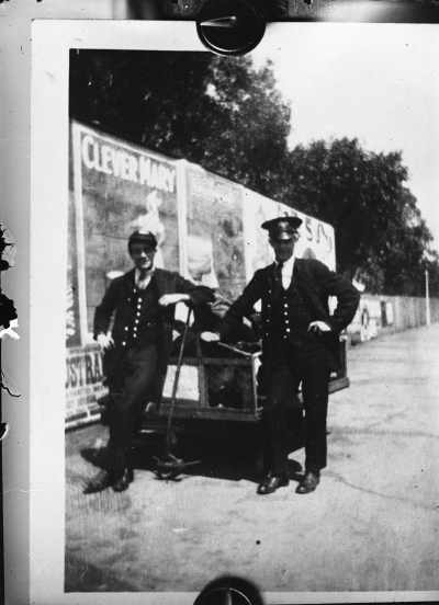 Railway porters and a luggage trolley on a railway platform.