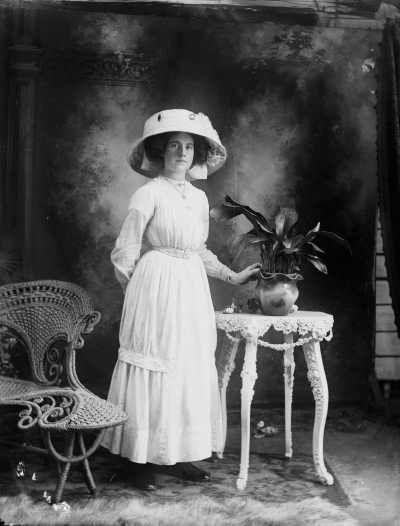 Studio portrait of  Miss May Pretty wearing a large hat.