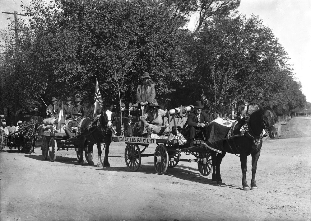 Decorated horse drawn wagons parading, possibly in  Benalla.
