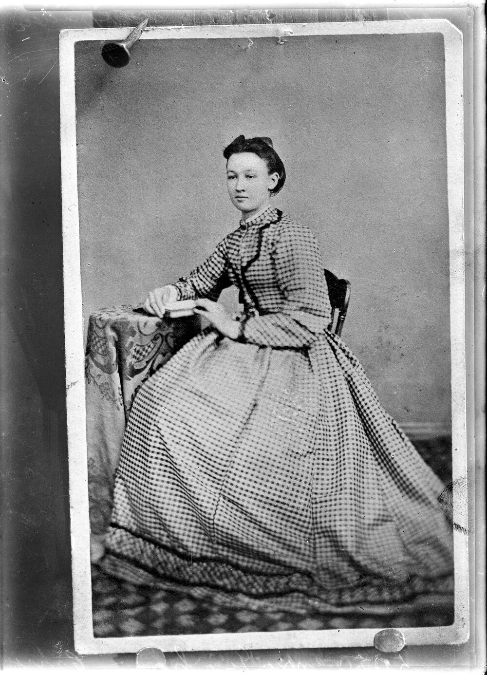 Portrait of a seated woman wearing a patterned dress.