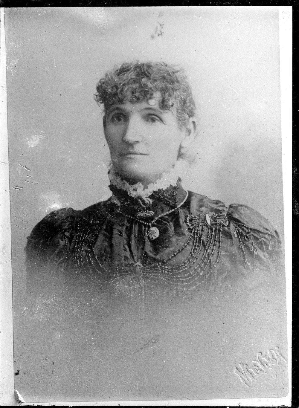 Portrait of an unidentified woman  wearing an elaborate dress with a high collar.