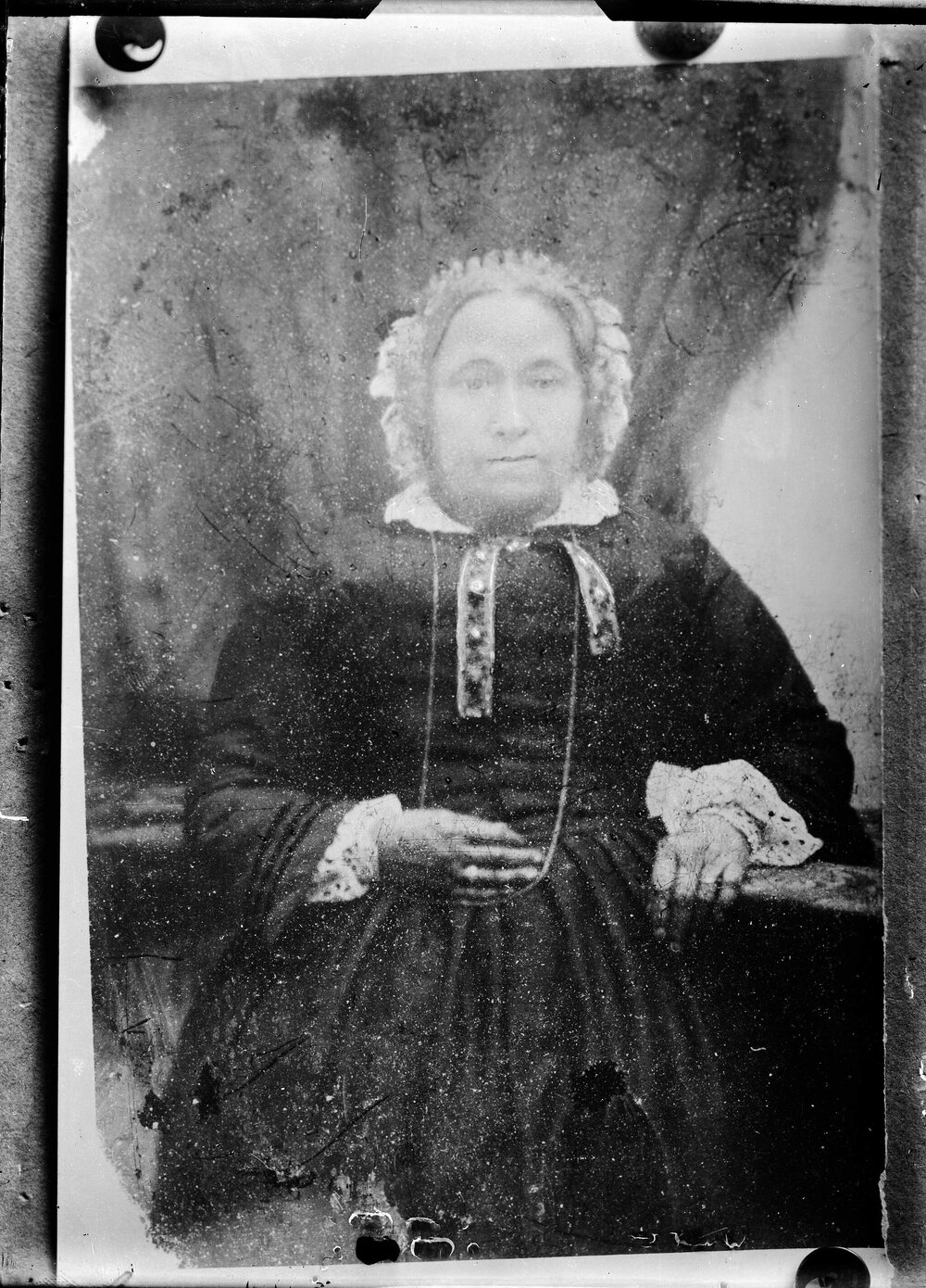 An unidentified seated woman wearing a bonnet.