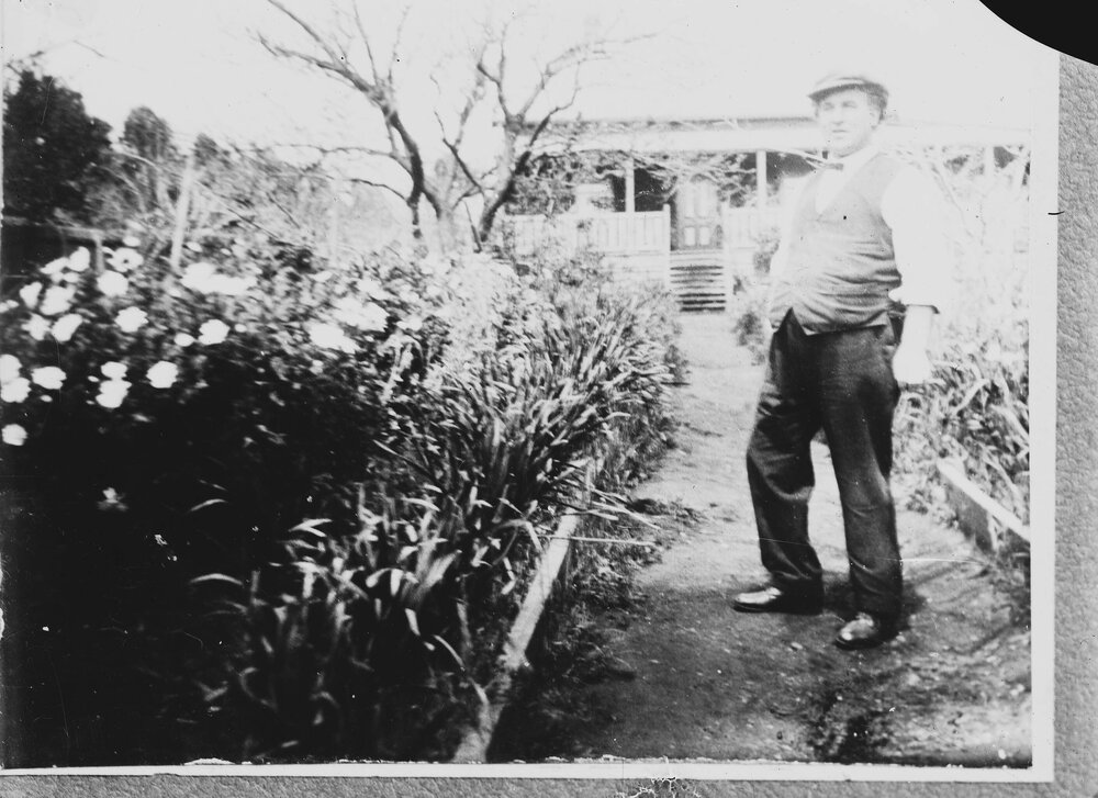 An unidentified man standing on a path in a garden.