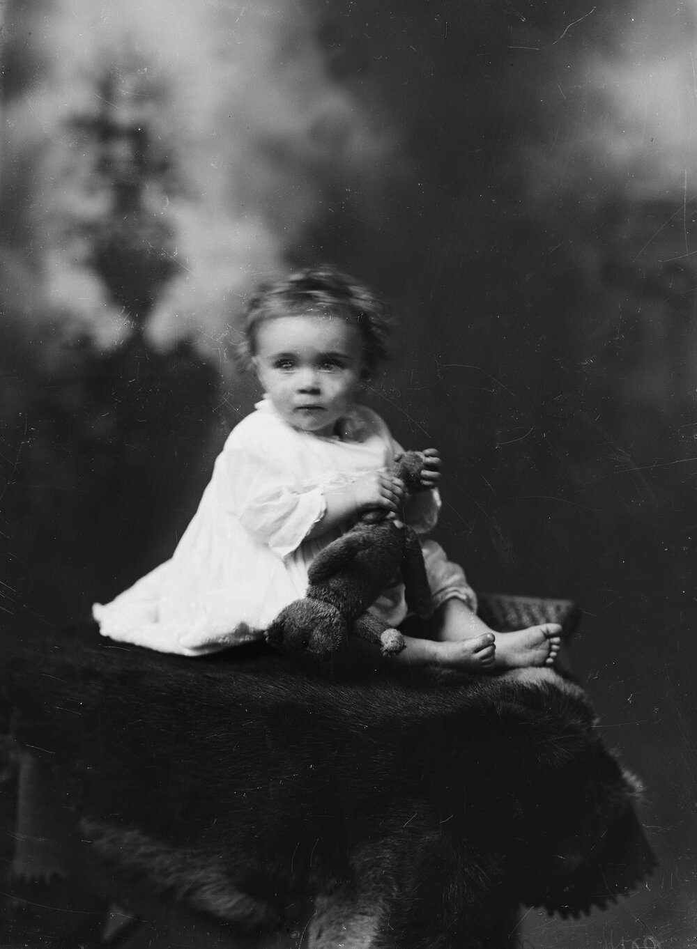 Portrait of an unidentified baby on a fur rug.