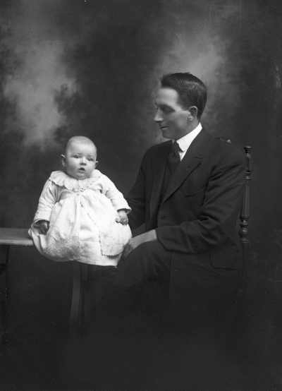 Studio portrait of Mr. C. Peterson and a baby.