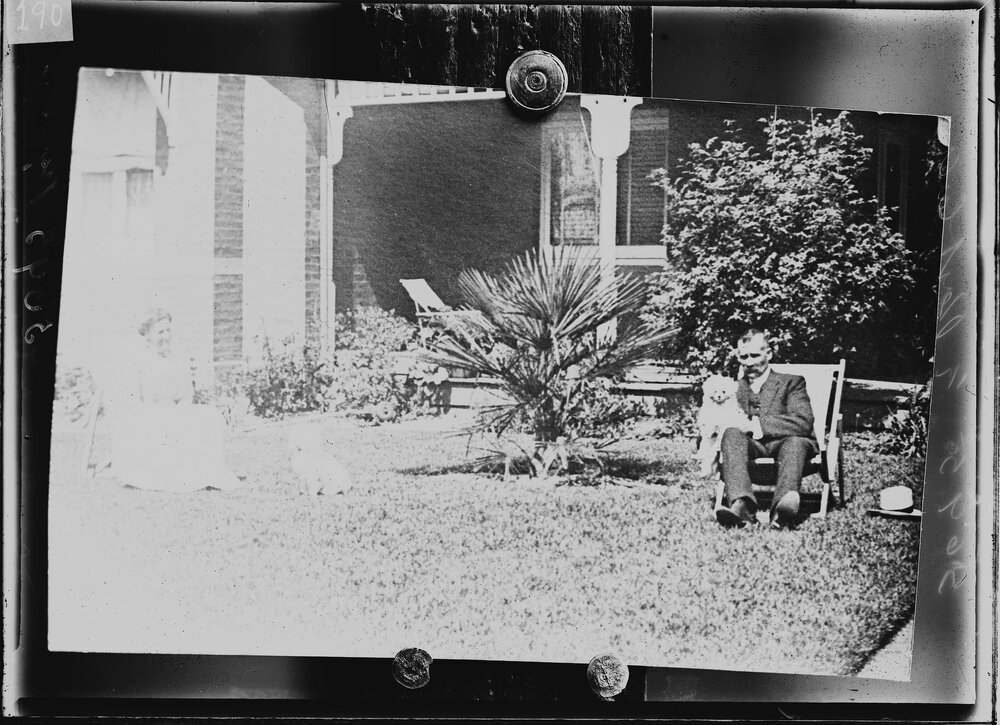 An unidentified man and woman in front of a brick Edwardian house.  Family name possibly Guppy.