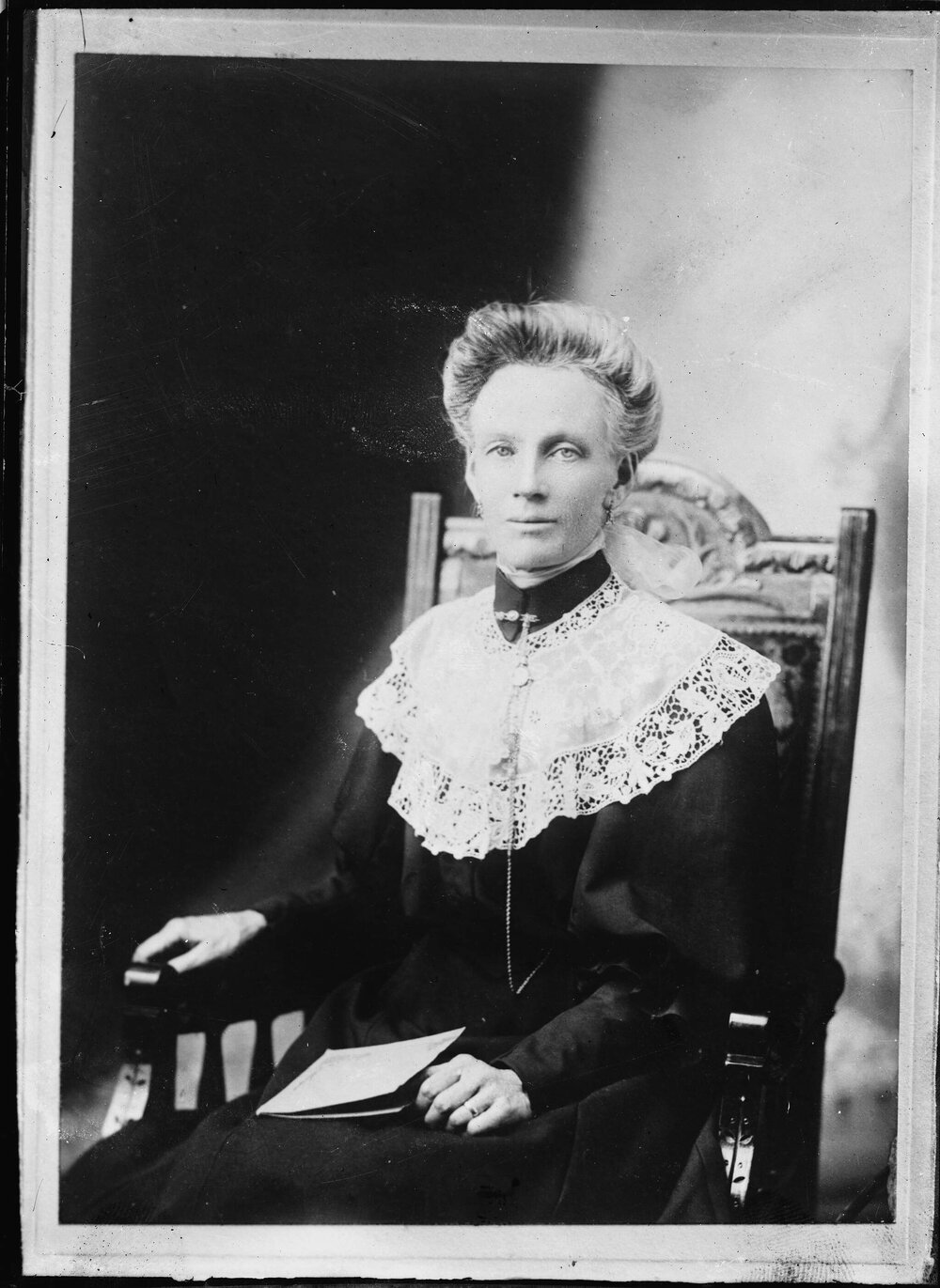 Studio portrait of an unidentified seated woman wearing a lace collar.
