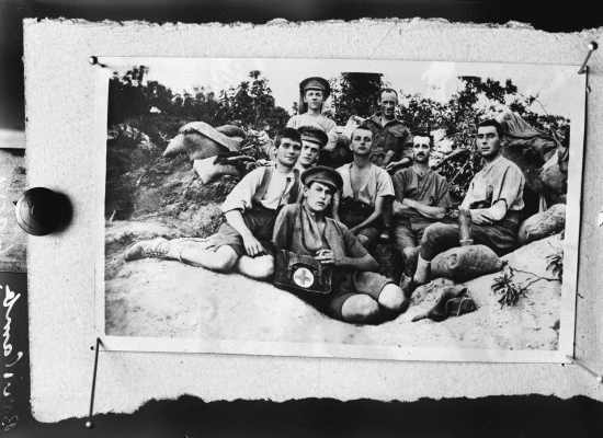 A group of eight men, some wearing items of military clothing.