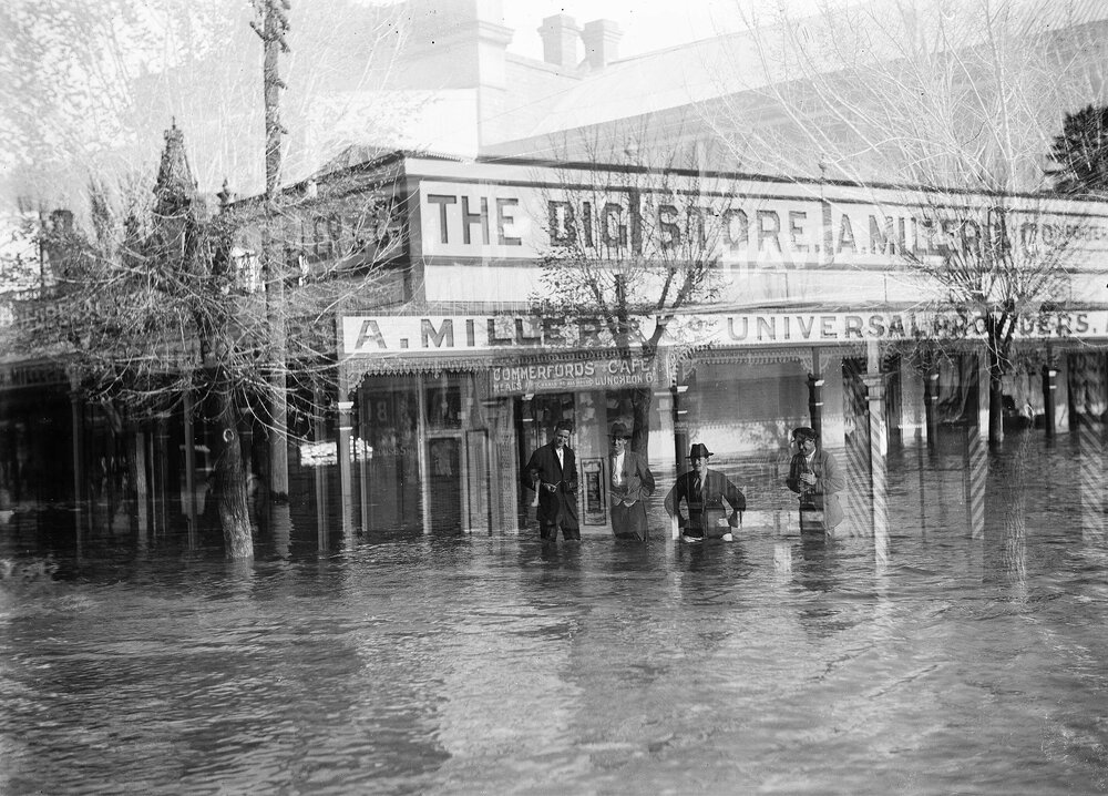Men standing in floodwaters in central Benalla.
