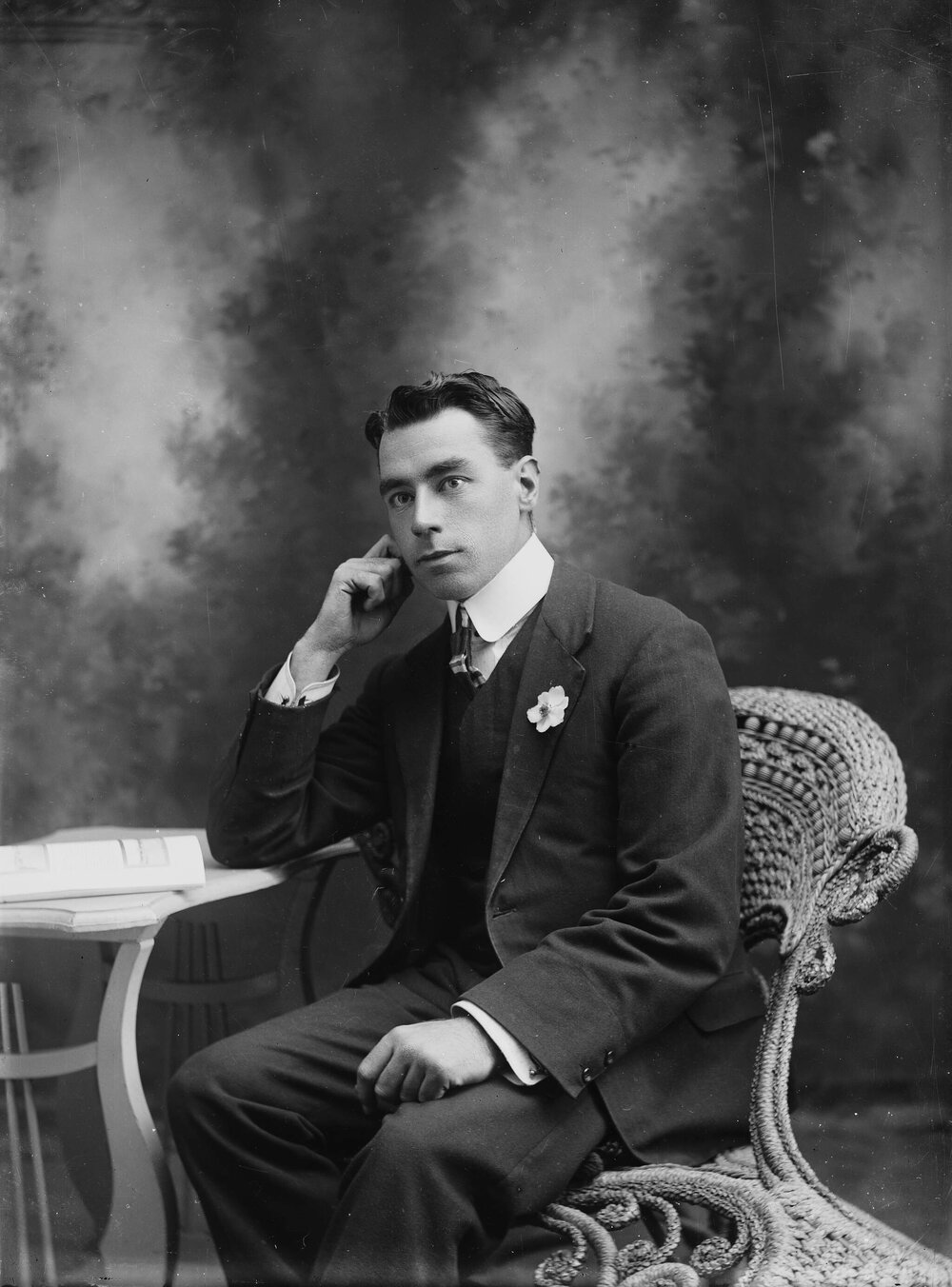 Studio portrait of a young man seated in a wicker chair.  Family name Gellispie or Gillispie.