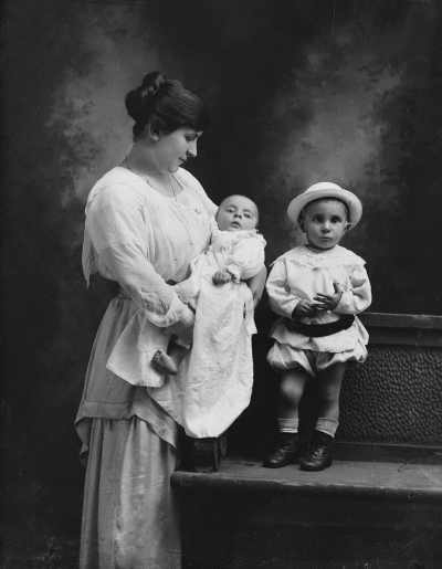 Studio portrait of a  woman  with two young children. Family name Eppas.