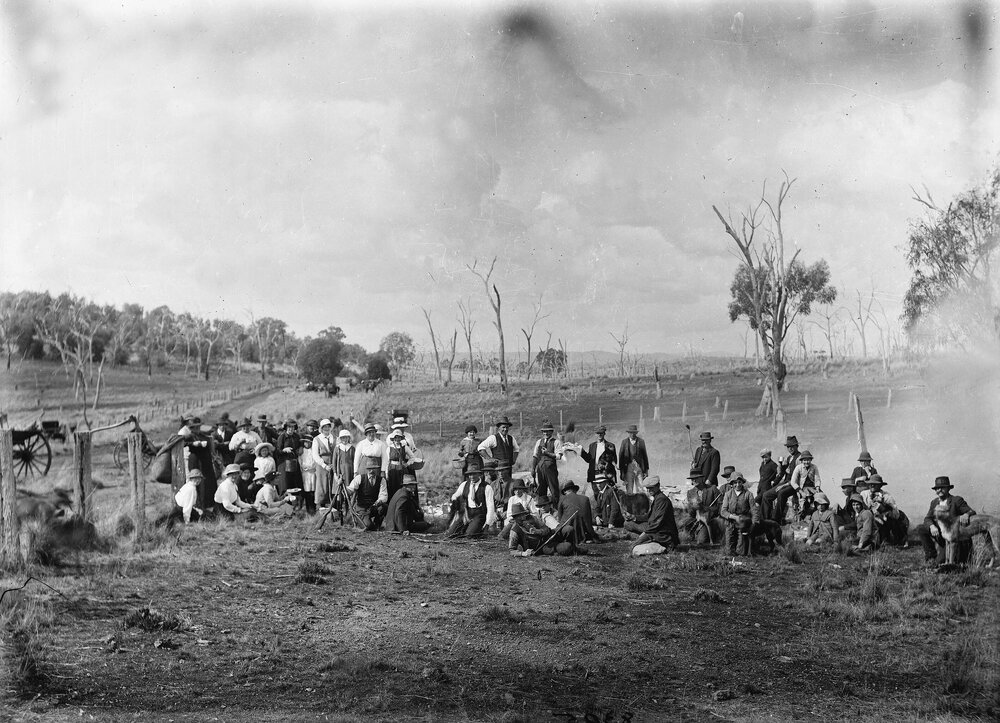 An unidentified group of people relaxing in a farmland environment.
