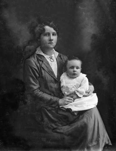 Studio portrait of Miss Johnson holding a baby.