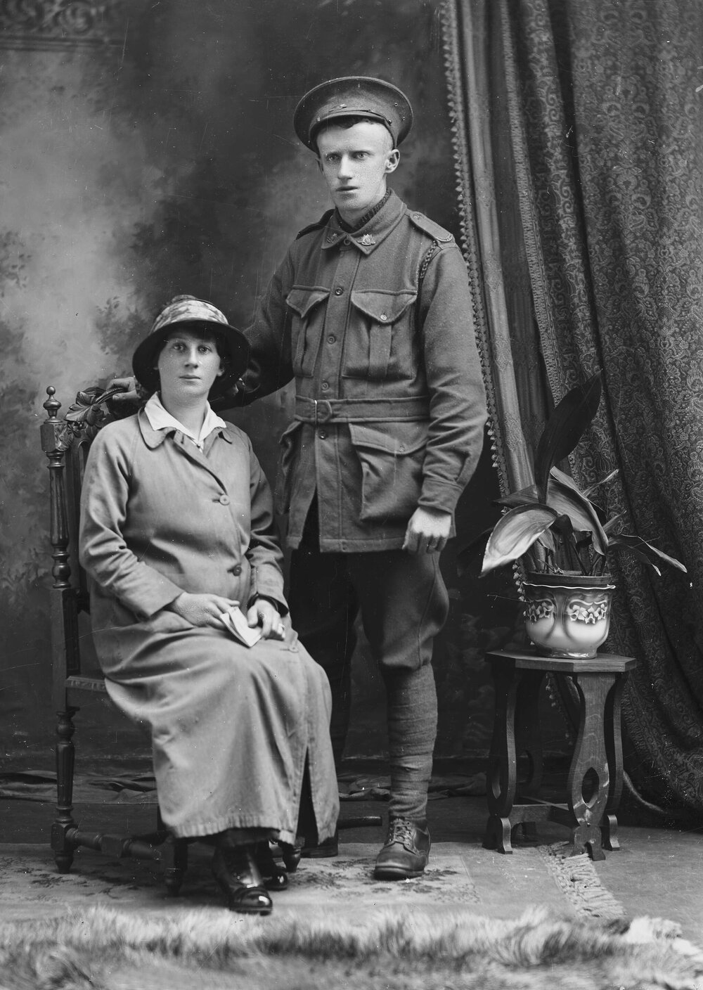 Studio portrait of a woman with a man in an Australian Army uniform.
