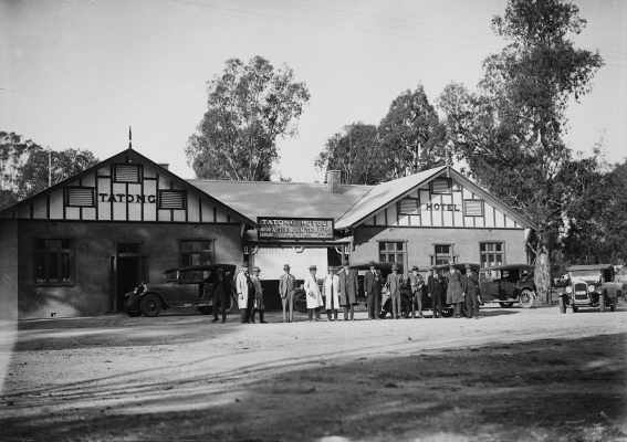 A group of men and cars outside the Tatong Hotel, Tatong.
