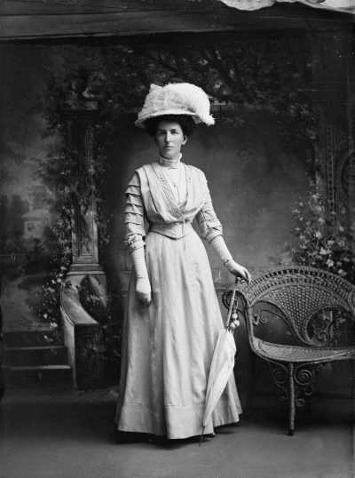 Studio portrait of a woman wearing a large feathered hat.  Family name Evans.