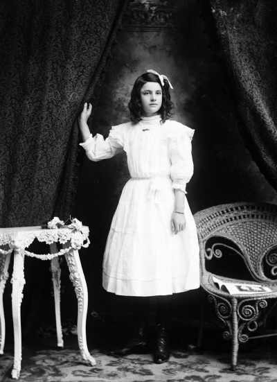 Studio portrait of a young woman in a white dress.  Family name Payne.
