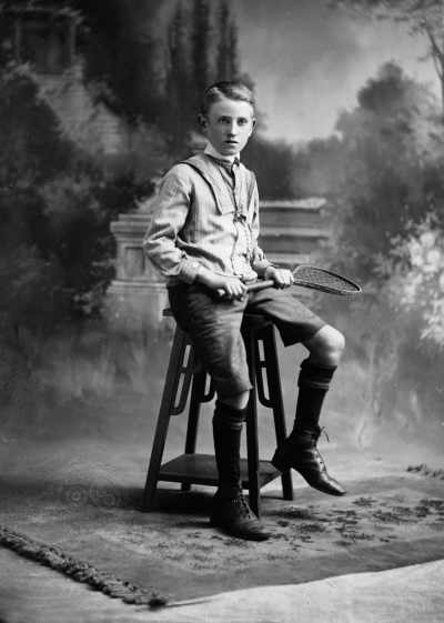 Studio portrait of a boy seated on a wooden pedestal.  Family name Allen.