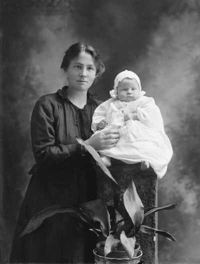 Studio portrait of Mrs. Donahoo with a baby.