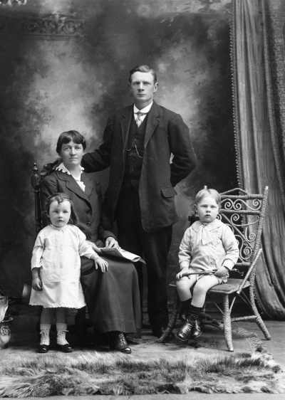 Studio group portrait of a woman and man with a boy and girl.  Family name Dixon.