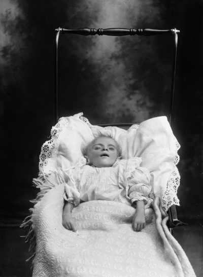Portrait of young child lying in a pusher.