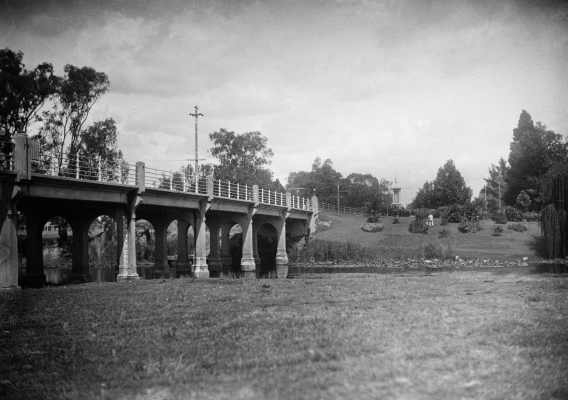 Public gardens and the reinforced concrete road bridge over the Broken River at Benalla.