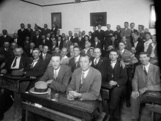 A group of men in a school classroom.