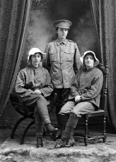 Studio portrait of three young woman in military style clothing.