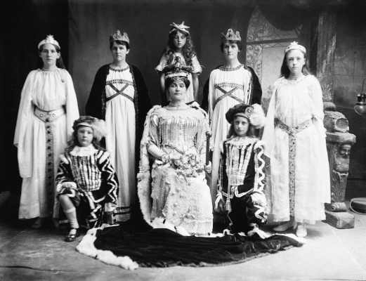 A posed mixed group of people dressed in theatrical costumes.