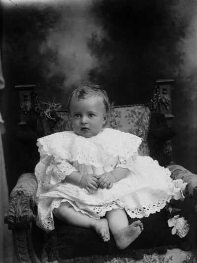 Studio portrait of a baby.  Family name possibly Mills.