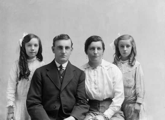 Portrait of a seated woman and man flanked by two girls.  Family name Bryce.