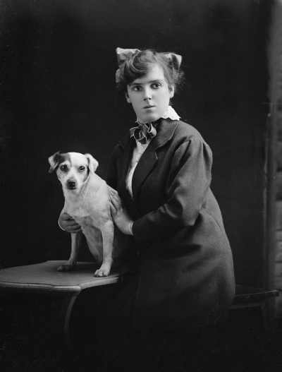 Studio portrait of a young woman and a dog.  Family name Jamieson or Jameson.