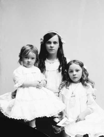 Portrait of three girls wearing white dresses.  Family name Bryne.
