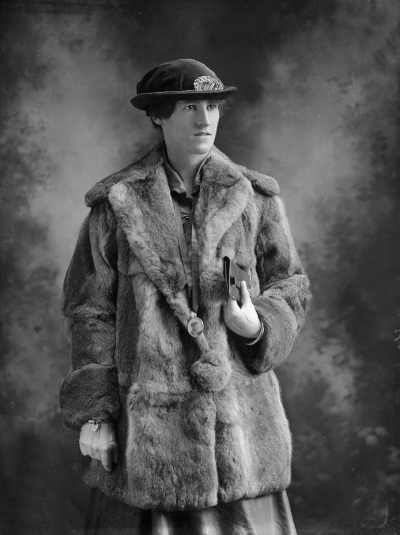 Studio portrait of Miss Kirby wearing a fur coat.